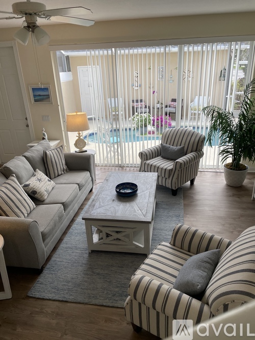 A living room with a striped couch and a ceiling fan.