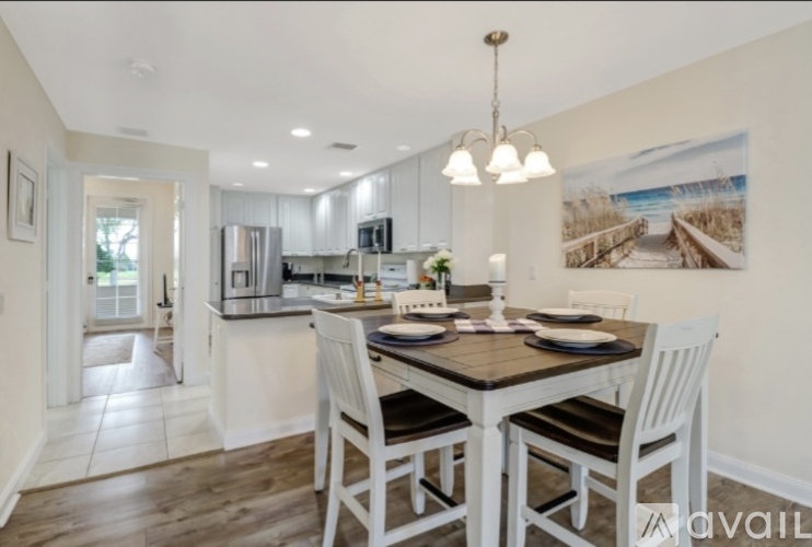 A modern kitchen with a dining table set for four.