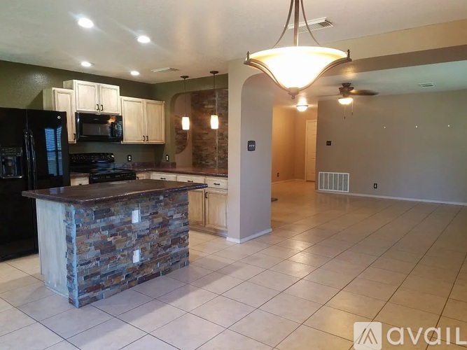 A kitchen with a stone island in the middle of the room.