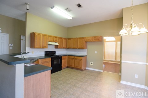 A kitchen with wooden cabinets and a black stove top oven.