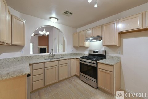 A kitchen with wooden cabinets and a granite countertop.
