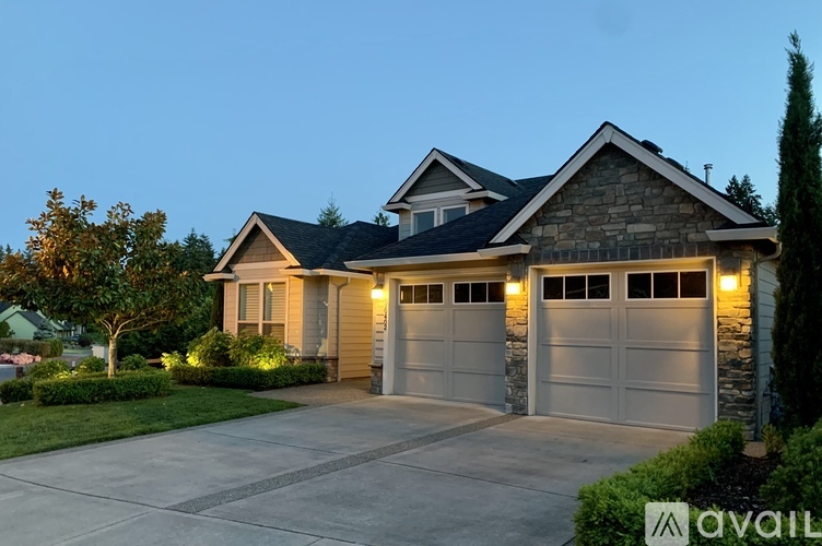 A house with a stone facade and two garage doors is available for sale.
