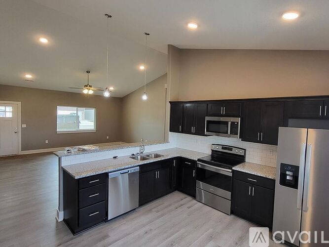 A kitchen with black cabinets and stainless steel appliances.