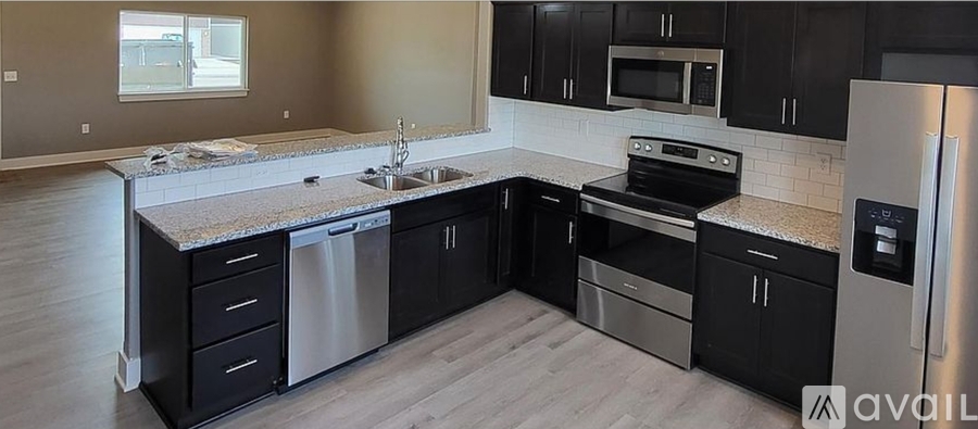 A kitchen with black cabinets and stainless steel appliances.