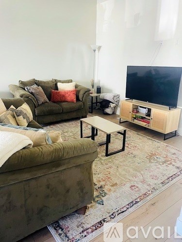 A living room with a green couch and a wooden coffee table.