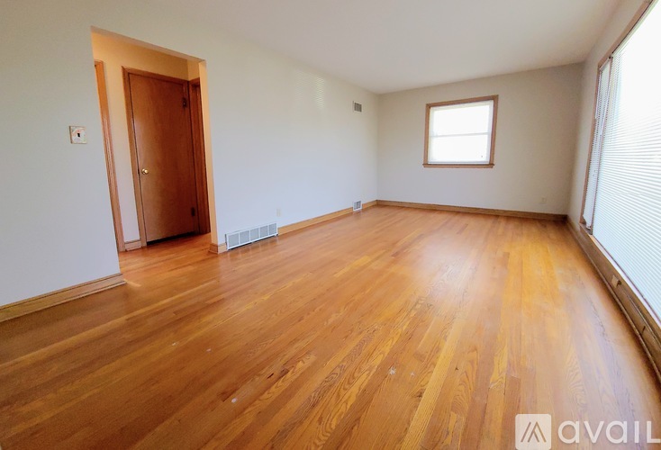 A room with wooden flooring and a window.