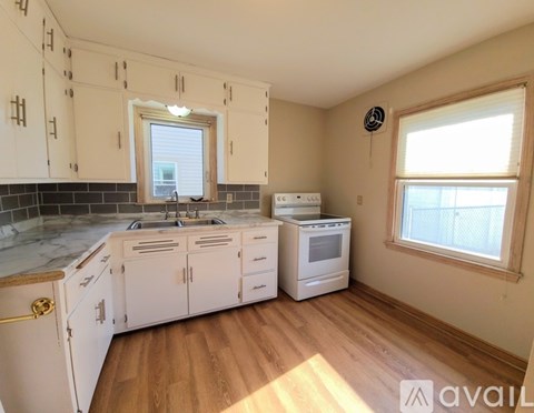 A kitchen with white cabinets and a marble countertop.