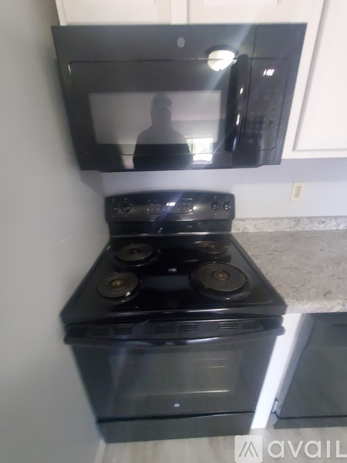 A black stove top oven with a microwave above it.
