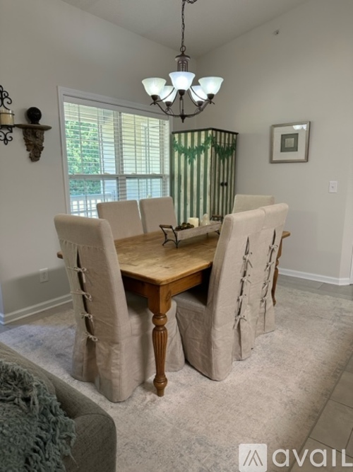 A dining room with a wooden table and chairs.