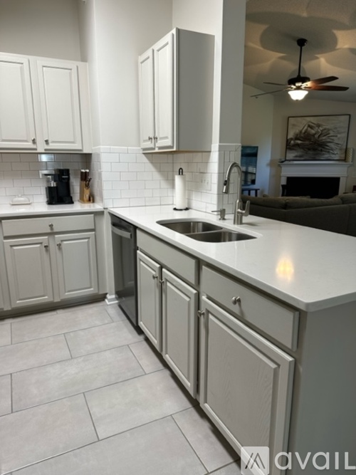 A kitchen with white cabinets and a sink.