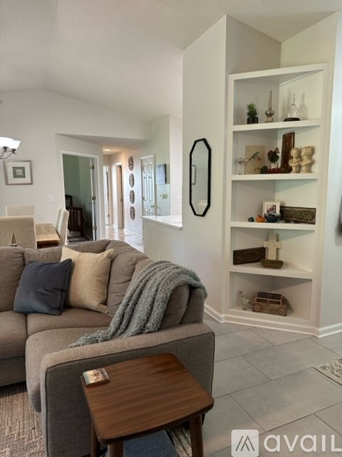 A living room with a grey couch and a wooden coffee table.