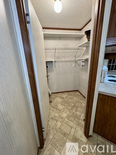 A small, white, tiled kitchen with a sink and a window.