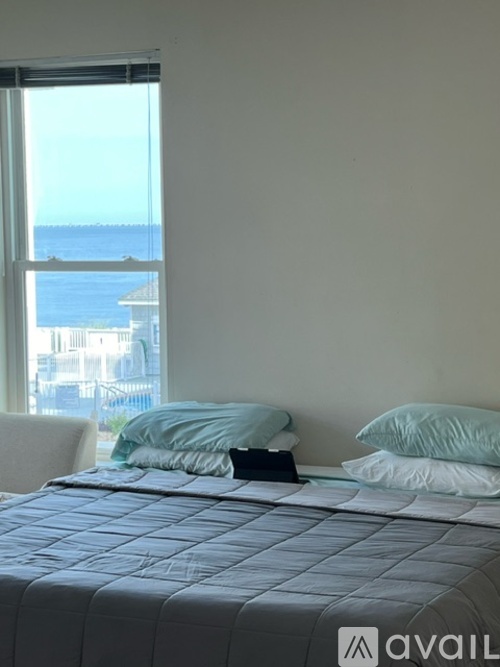A bedroom with a large bed and a view of the water.