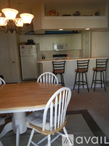 A kitchen with a table and chairs in front of it.