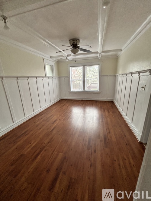 A room with wooden floors and a ceiling fan.