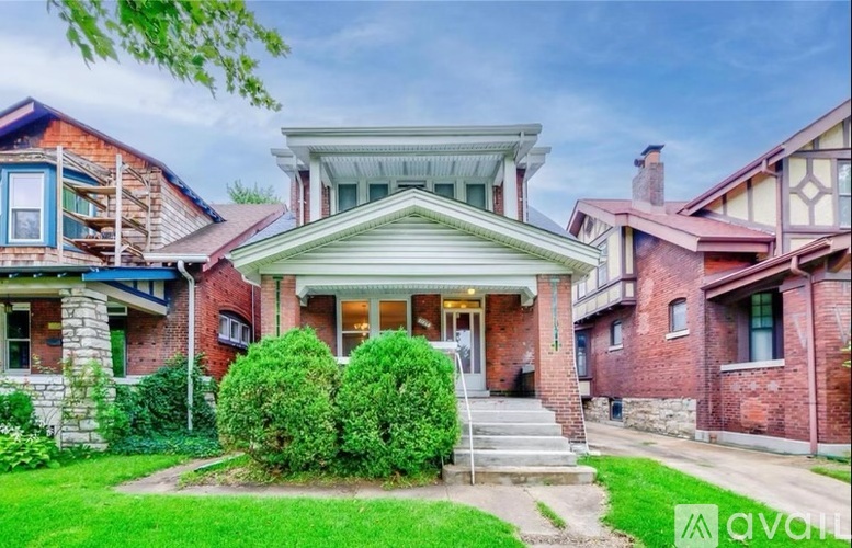 A house with a green lawn in front of it.