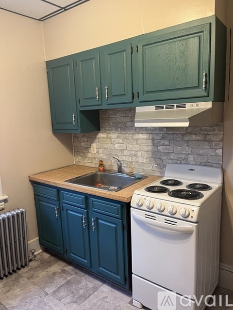 A kitchen with a white stove and blue cabinets.