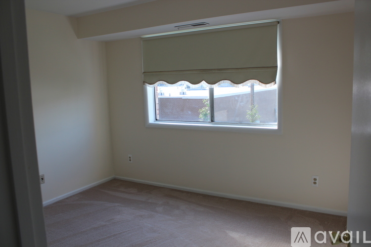 A room with a window covered by a white blind.