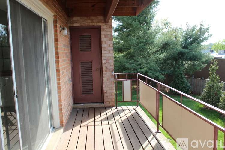 A wooden deck with a red door and a glass door.