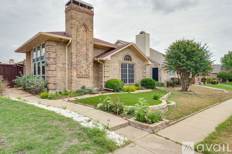 A house with a brick chimney and a stone wall.