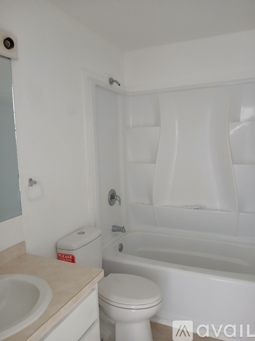 A white toilet sits next to a sink in a bathroom.