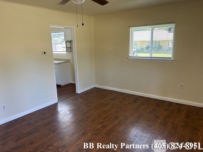 A room with a window and a door leading to another room.