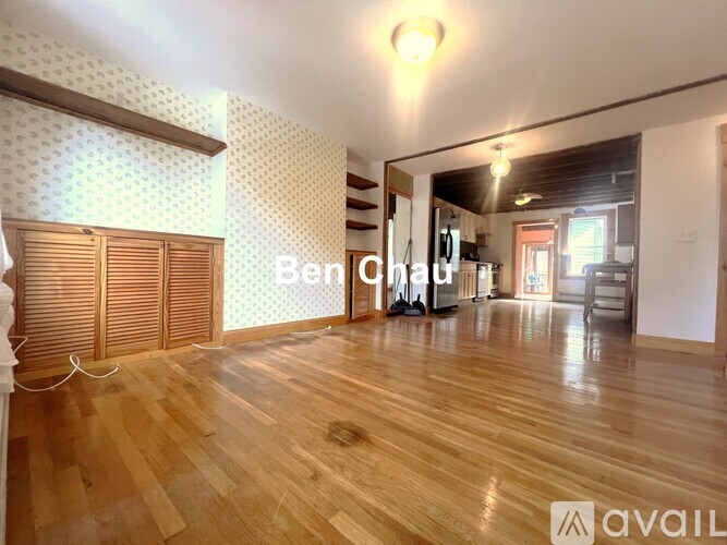 A room with wooden flooring and a wall with a patterned design.