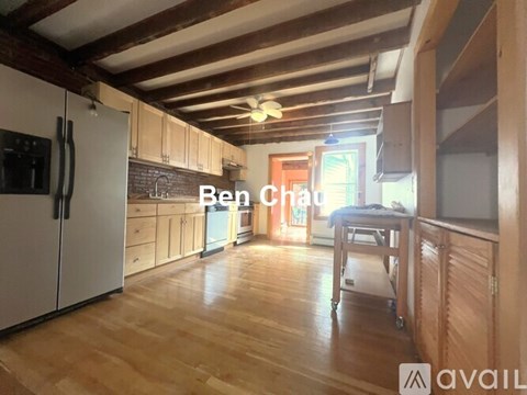 A kitchen with wooden floors and a refrigerator.