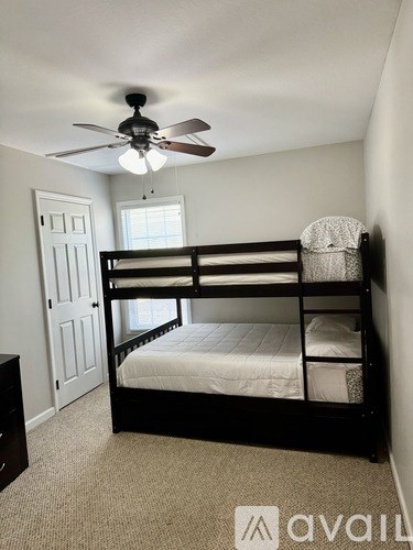 A bedroom with a bunk bed and a ceiling fan.