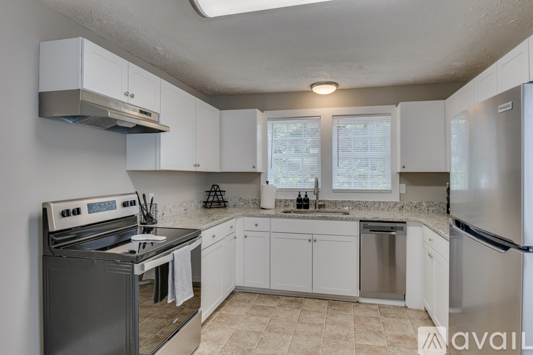 A kitchen with white cabinets and a stainless steel refrigerator.