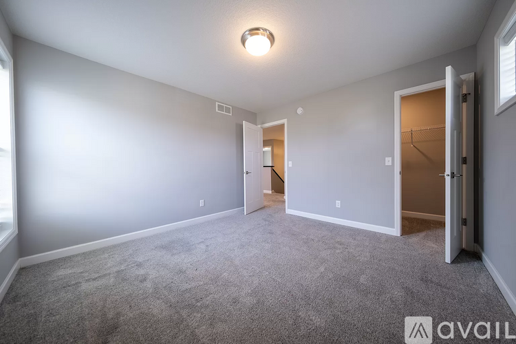A spacious room with a carpeted floor and a single light fixture on the ceiling.