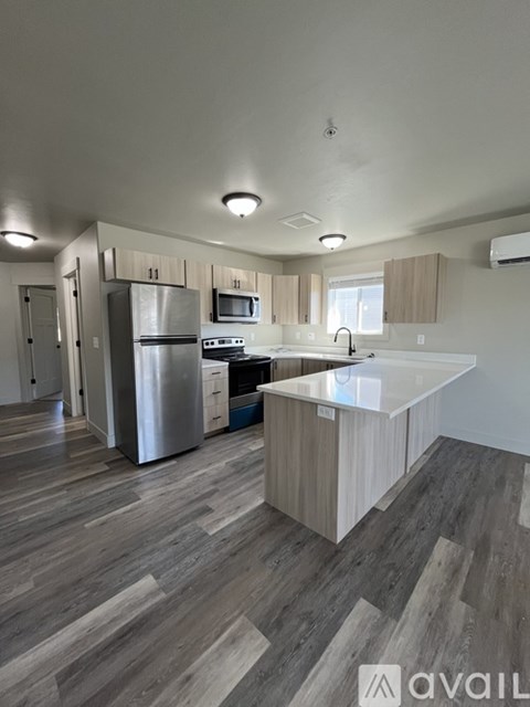 A kitchen with wooden floors and stainless steel appliances.