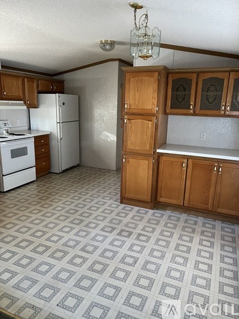 A kitchen with a white refrigerator and wooden cabinets.