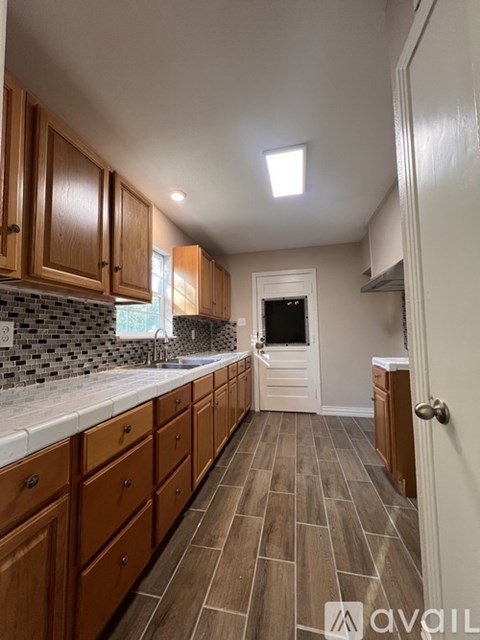 A kitchen with wooden cabinets and a tiled backsplash.