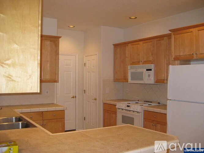 A kitchen with wooden cabinets and a white refrigerator.