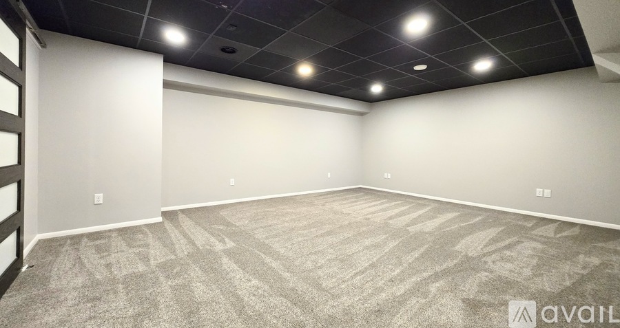A spacious room with a carpeted floor and a ceiling with lights.