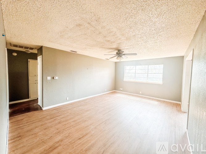 A room with wooden flooring and a ceiling fan.
