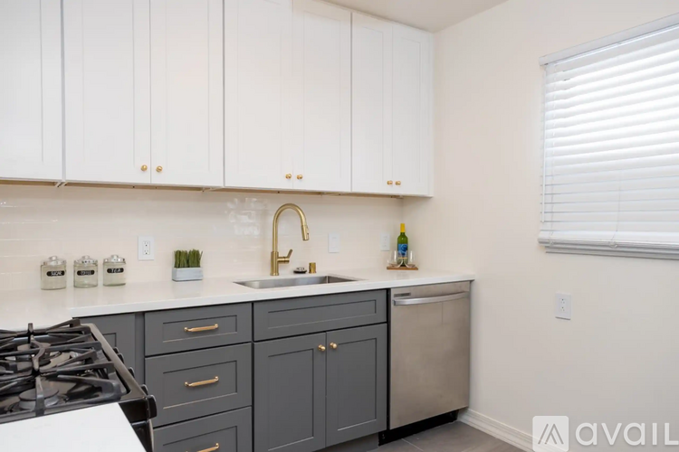 A kitchen with white cabinets and a black stove top.