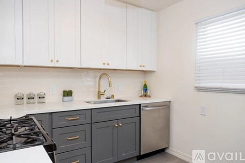 A kitchen with white cabinets and a black stove top.