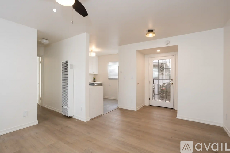 A spacious living room with a ceiling fan and hardwood floors.