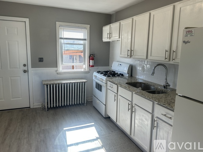 A kitchen with white appliances and cabinets.