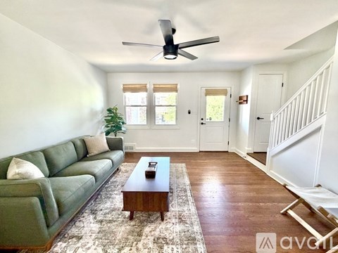 A living room with a green couch and a wooden coffee table.