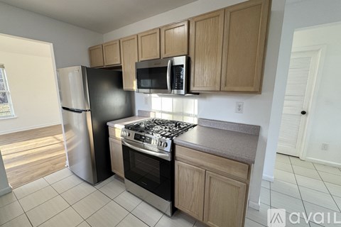 A kitchen with a stainless steel refrigerator, microwave, and oven.