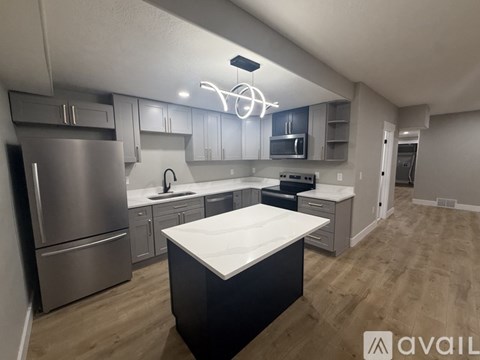 A modern kitchen with stainless steel appliances and a central island.
