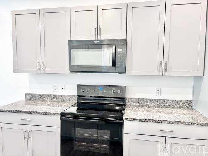 A kitchen with a black oven and white cabinets.