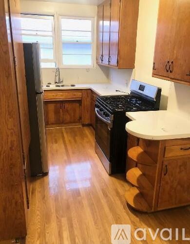 A kitchen with wooden cabinets and a black stove top oven.