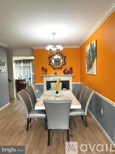 A dining room with a wooden table and grey chairs.