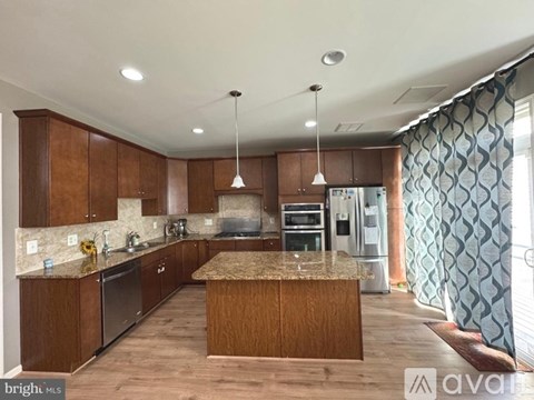 A kitchen with wooden cabinets and a granite countertop.