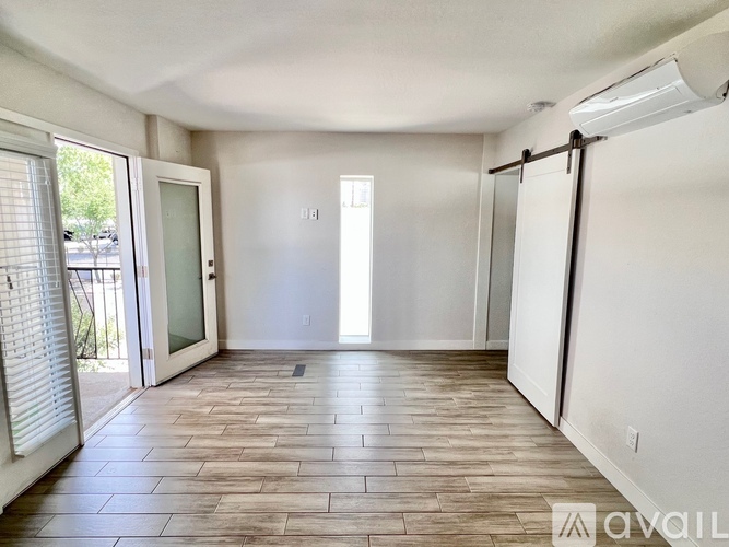 A spacious room with a sliding glass door and a wooden floor.