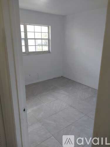 A room with a window and tiled floor.